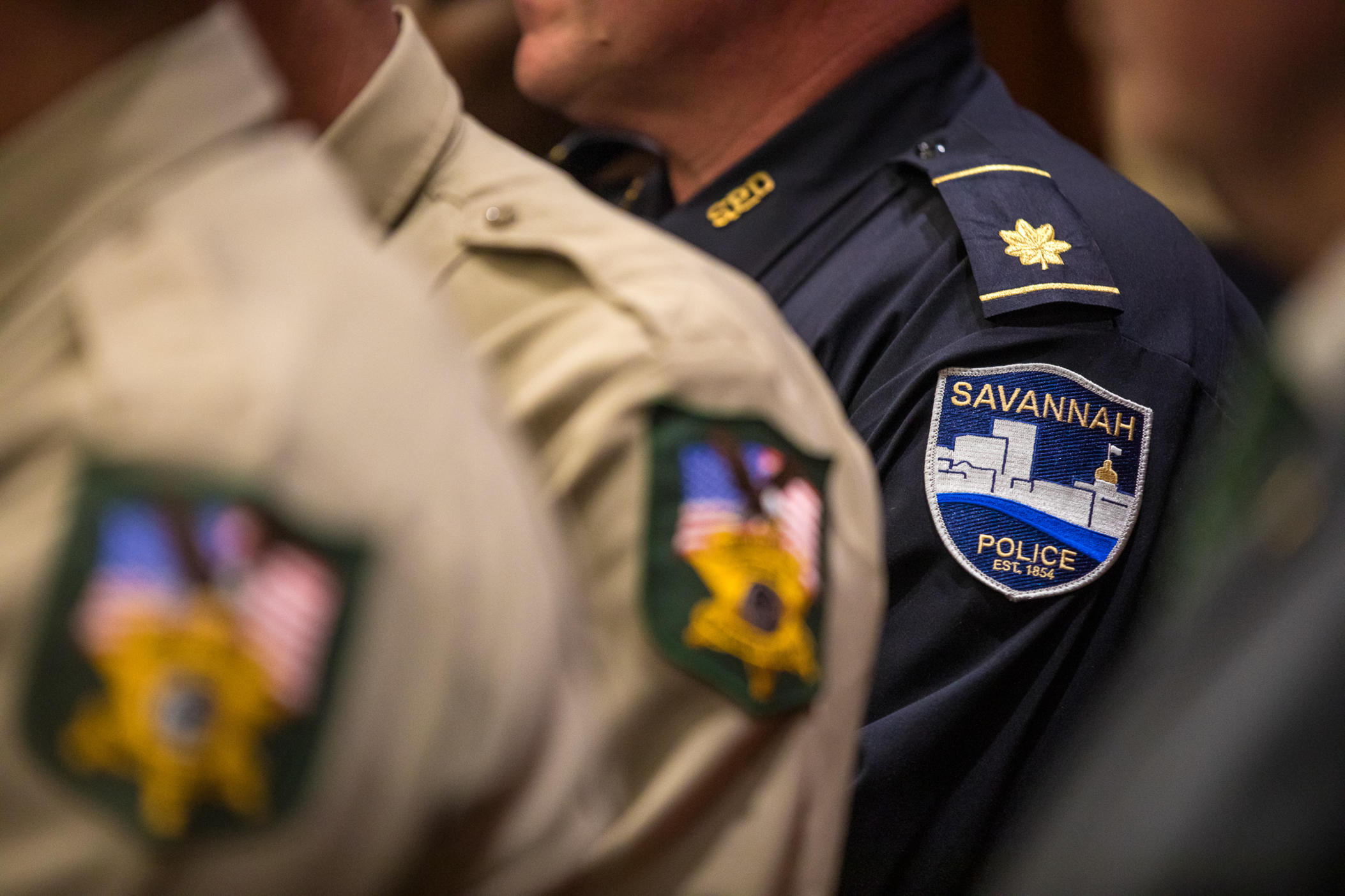 ©Riley Bunch/GPB: News Officers from law enforcement departments that have already implemented co-responder units gather at the Georgia Capitol on May 9 to watch Gov. Brian Kemp sign Senate Bill 403. 