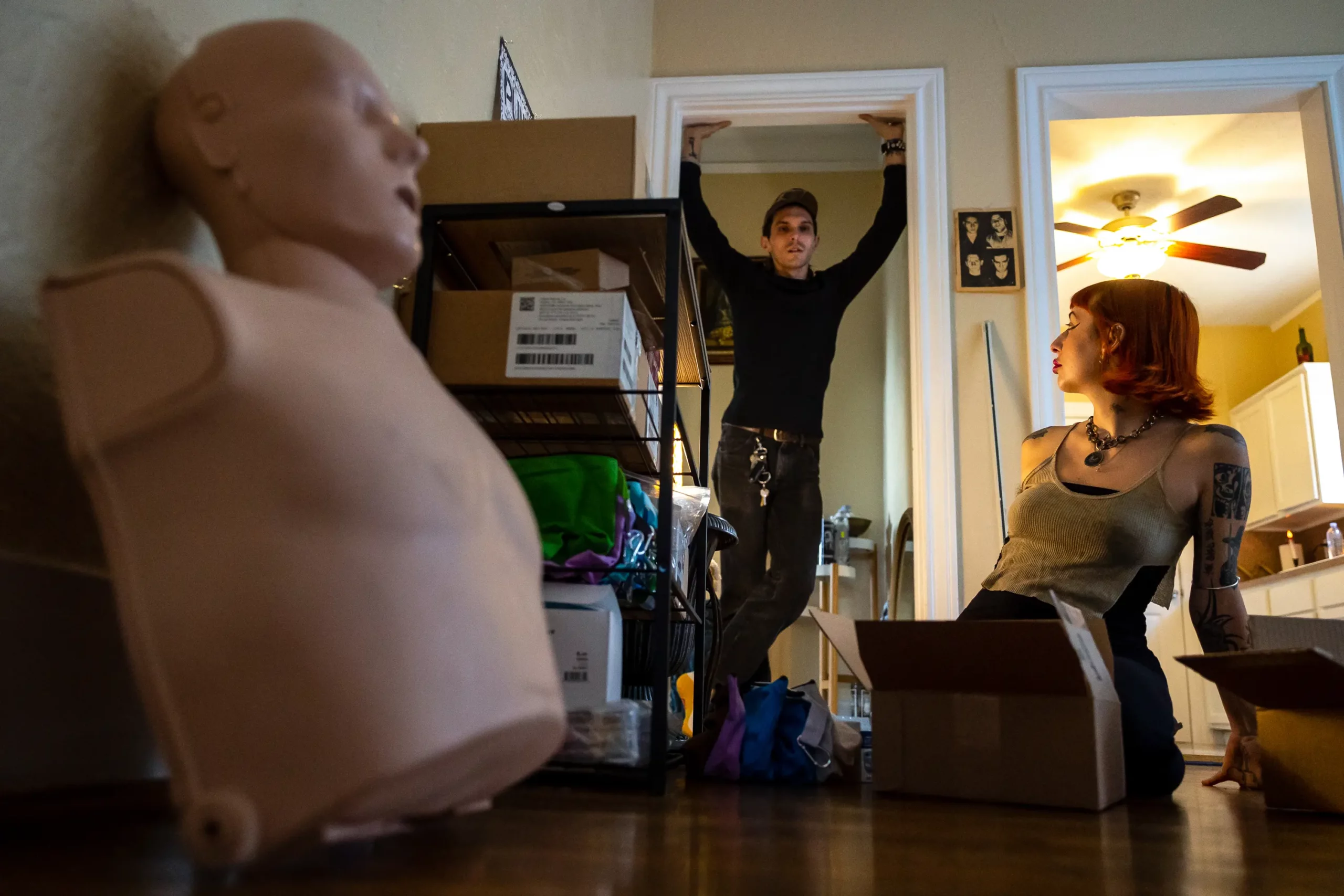 ©Annie Mulligan/The Texas Tribune: Devin Mathieu and his partner, Claudia Dambra, discuss someone who might need a package containing life-saving harm reduction supplies in their apartment on Sept. 16.