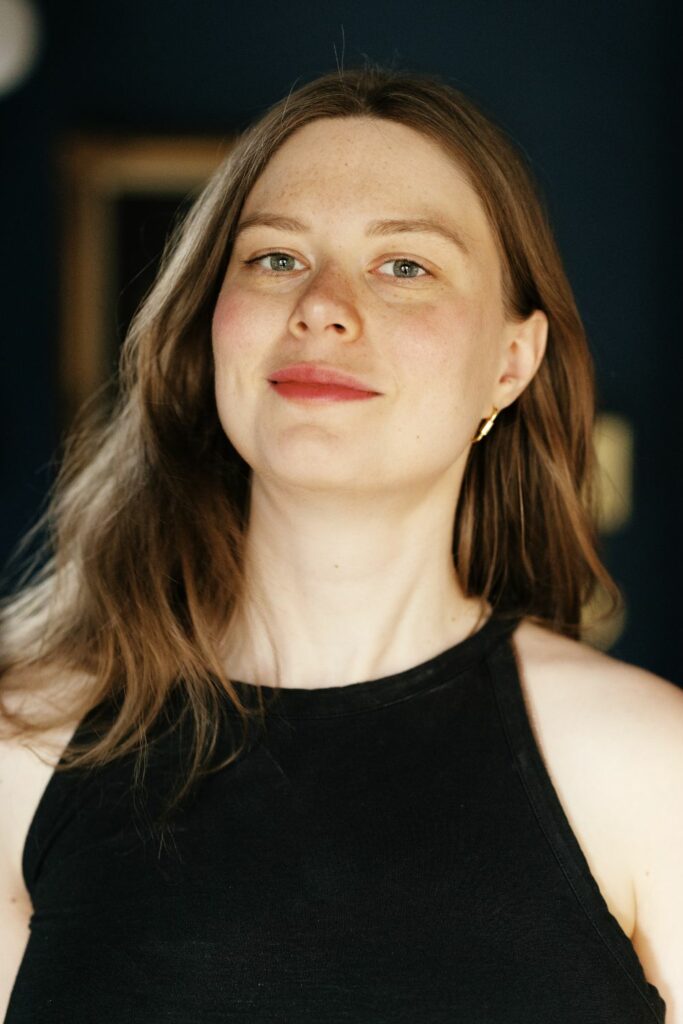 Image of Emi in a black dress looking at the camera.