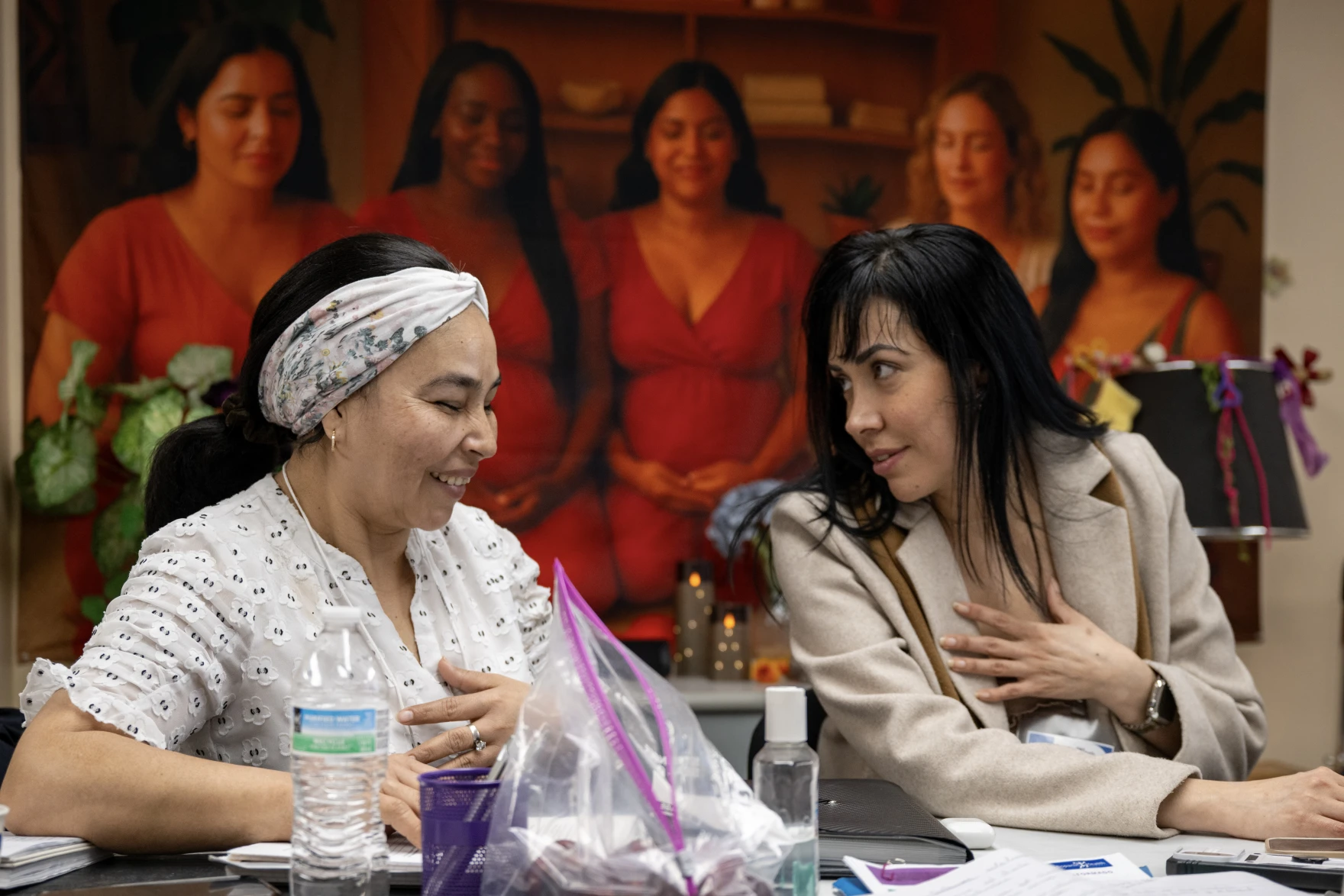 Juana Lenny (left) and Diana Luna (right) discuss an assignment as part of a certification program for Spanish-speaking women to become doulas. They are training at the Hispanic Health Council in Hartford on March 31, 2026. (Tyler Russell / Connecticut Public)