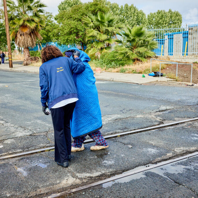 Community organizer Desiree Rushing hands out food to people experiencing homelessness in Antioch. Rushing goes out every week connecting unhoused people with food, supplies, and resources through the National Alliance on Mental Illness (NAMI) Contra Costa County chapter. ©Gabriela Hasbun for California Health Report/CatchLight 