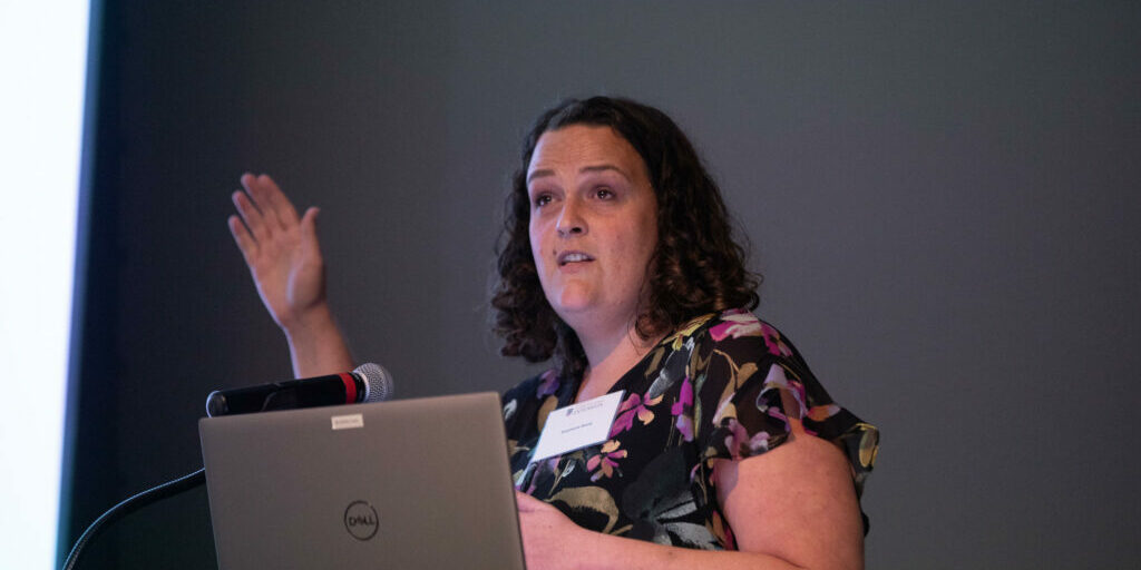©Riley Bunch/GPB News: Stephanie Basey, a doctoral student at Mercer University School of Medicine, presents findings on the mental health of Georgia's farmers at a summit in Tifton on May 18. Industry experts seek to get resources to farmers, who don't always know where to turn for help. 