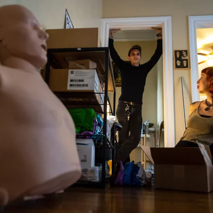 ©Annie Mulligan/The Texas Tribune: Devin Mathieu and his partner, Claudia Dambra, discuss someone who might need a package containing life-saving harm reduction supplies in their apartment on Sept. 16.