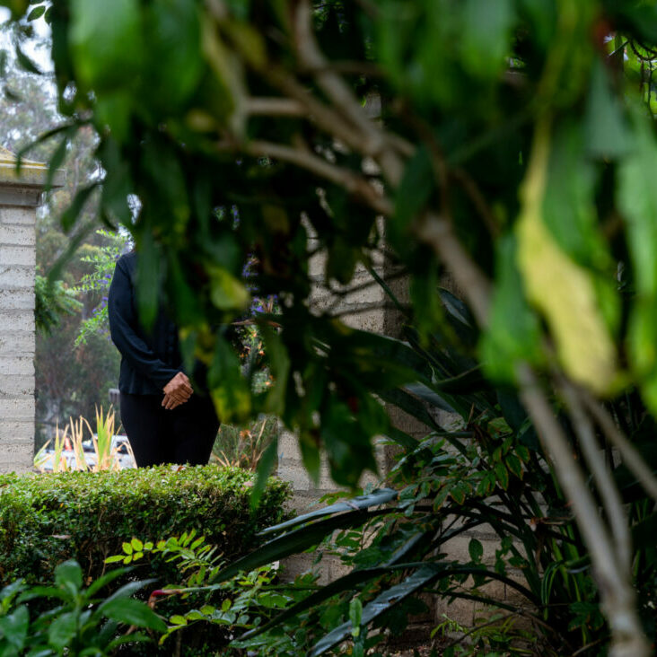 Women hidden by trees.